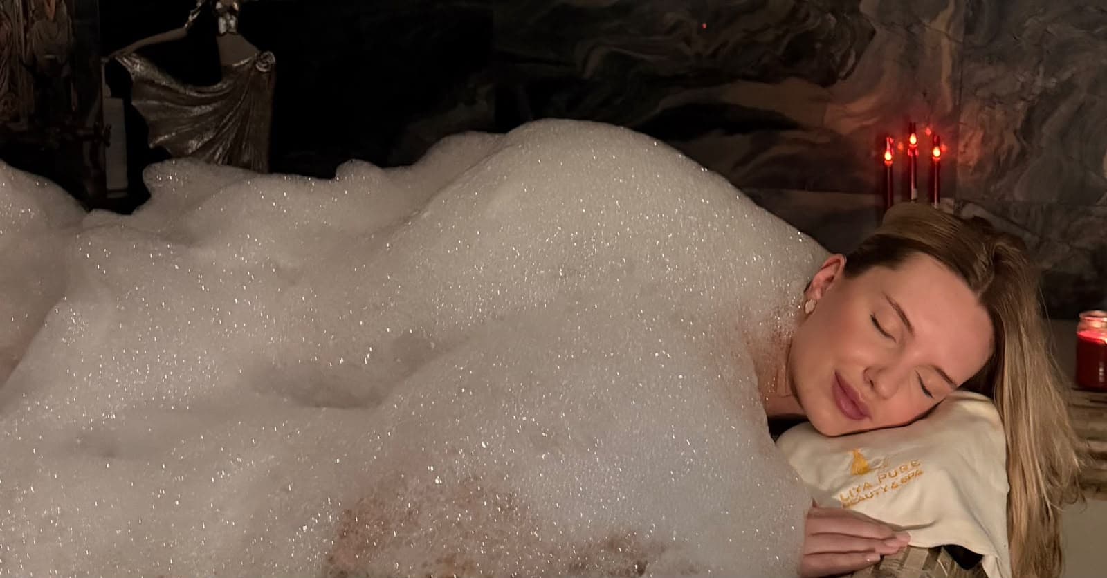 Guest relaxing under a blanket of hammam foam by candlelight